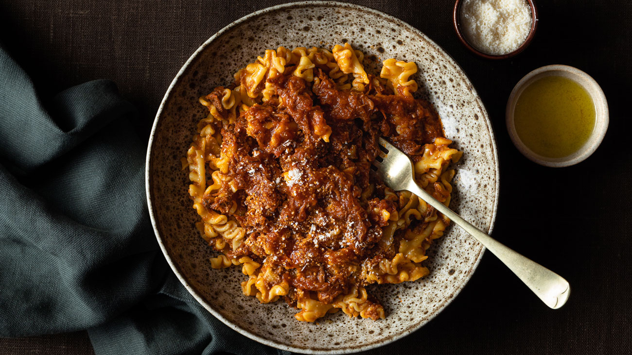 Pappardelle pasta in tomato sauce with meat, served on a plate.
